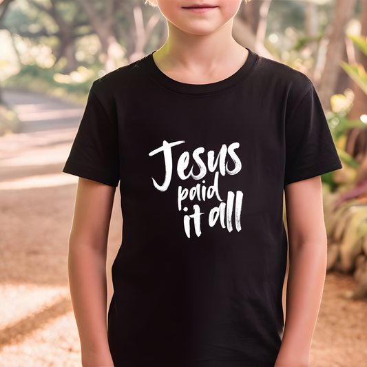 Young boy smiling wearing Jesus Paid It All kids Christian t-shirt in white by Abound in Faith