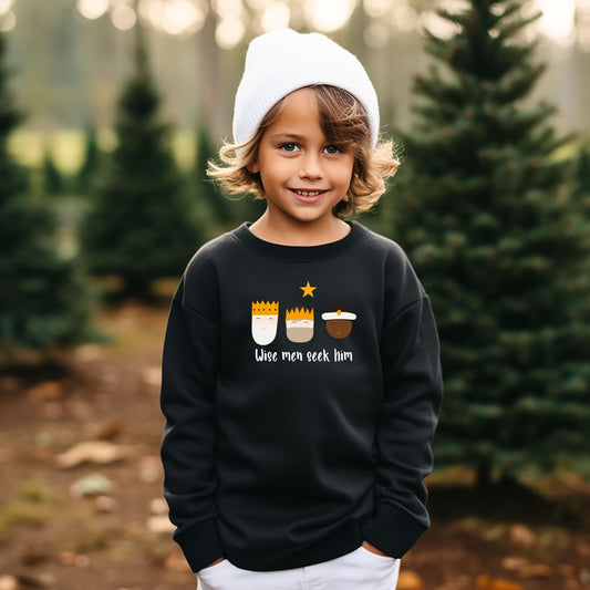 Young boy wearing black Christian hoodie with ‘Wise men seek Him’ design featuring three wise men – holiday apparel by Abound in Faith.