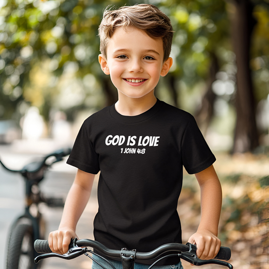 A boy smiling wearing a Black kids God Is Love kids hoodie Bible verse printed in white text.