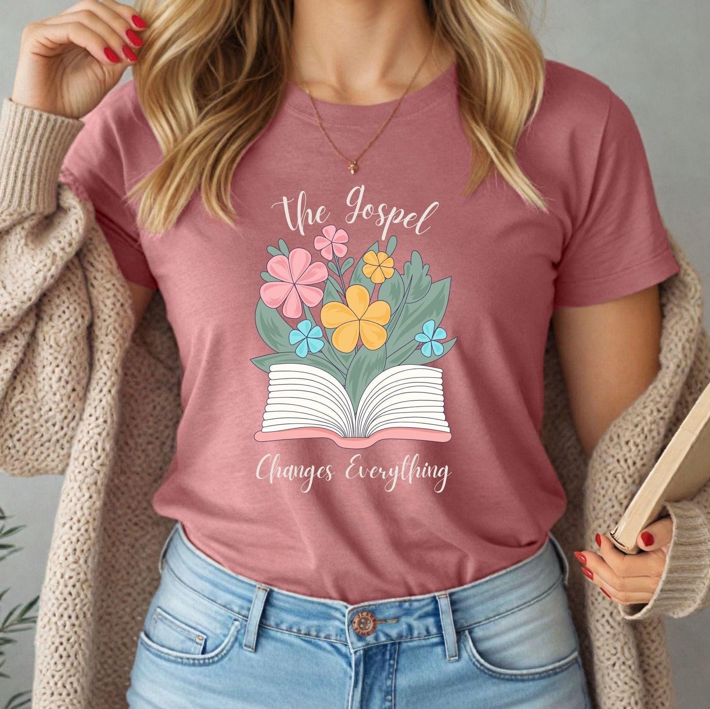Woman wearing mauve Bella Canvas t-shirt with The Gospel Changes Everything floral Bible design by Abound in Faith