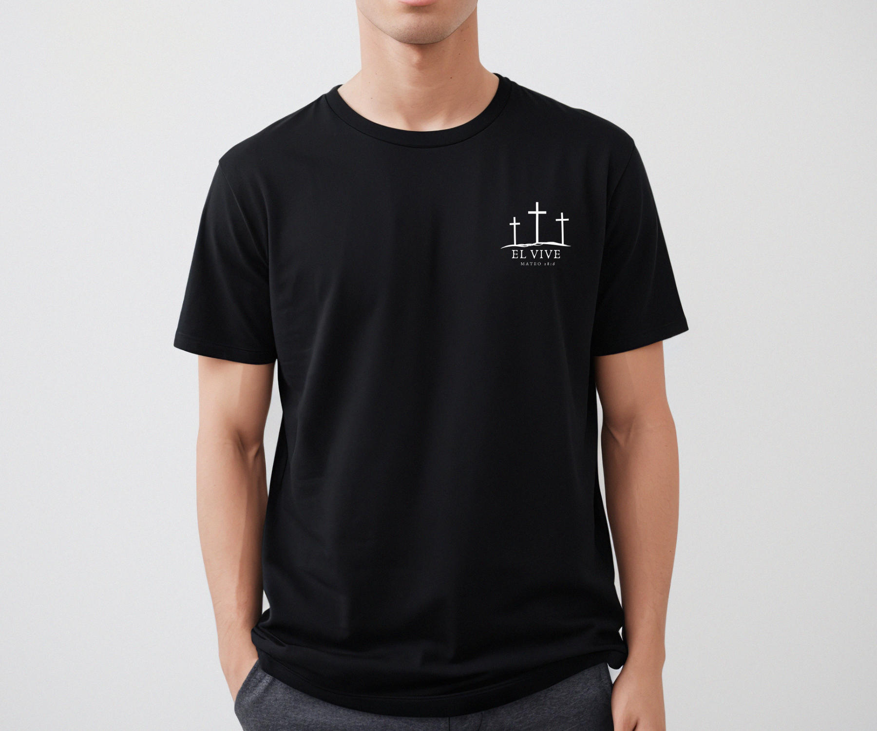 "Camiseta cristiana 'El Vive' en español, con texto inspirador sobre fondo suave, disponible en AboundInFaith.com"