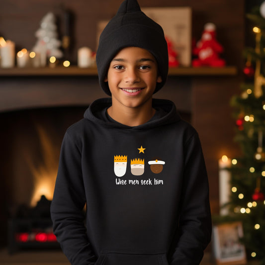 Young boy wearing black Wise Men Seek Him Boys Hoodie design featuring three wise men – holiday apparel by Abound in Faith.