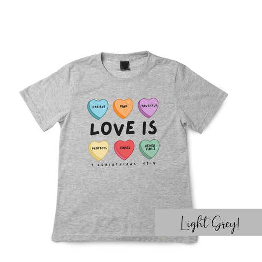 Light grey kids Christian t-shirt with colorful candy hearts and “Love Is” theme from 1 Corinthians 13