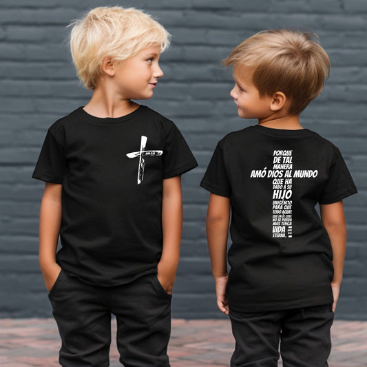 Two boys wearing black Camiseta Infantil Juan 3:16 with cross design; front features a brush-stroke cross, and back displays John 3:16 verse in Spanish.