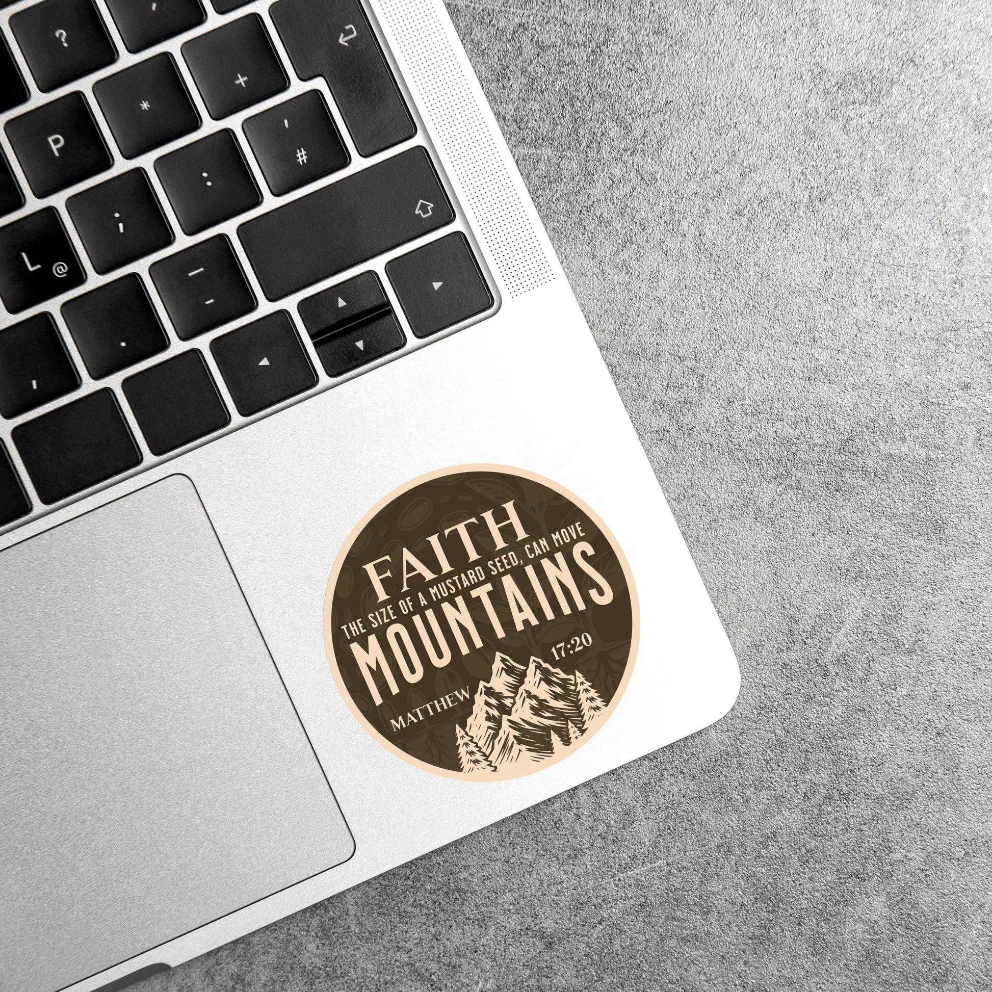 Faith Can Move Mountains waterproof sticker with Matthew 17:20 on a leather laptop