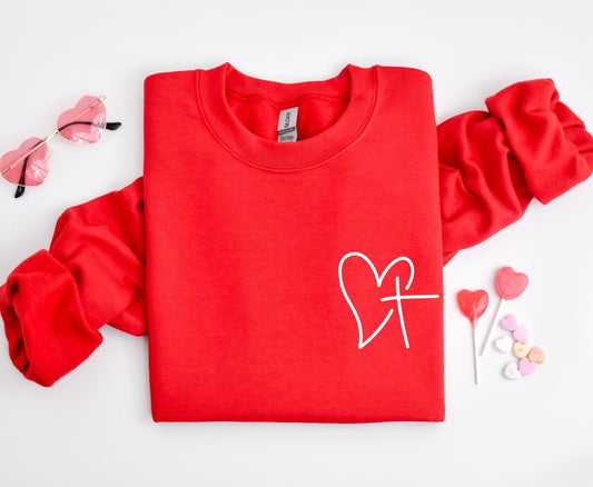 Red sweatshirt folded with white cross and heart graphic – Heart of Faith Christian Sweatshirt