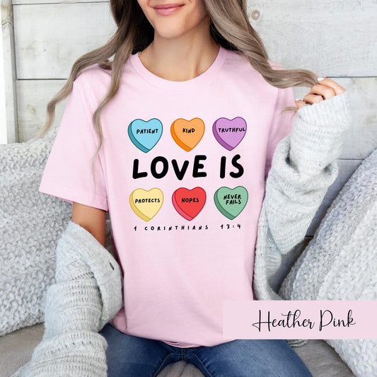 Pink Christian t-shirt for women with Love Is conversation hearts design based on 1 Corinthians 13:4 scripture