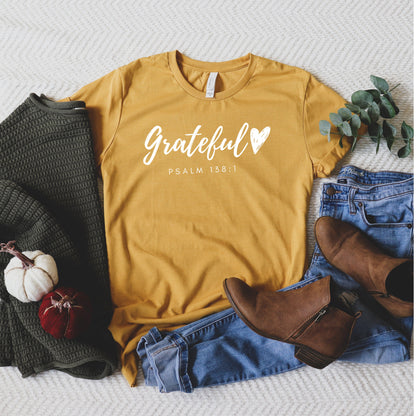 Grateful Heart” Christian t-shirt in fall colors (mustard, mauve, heather brown, burgundy, and black) with Psalm 138:1 verse design. Ideal for Thanksgiving and faith-based outfits.