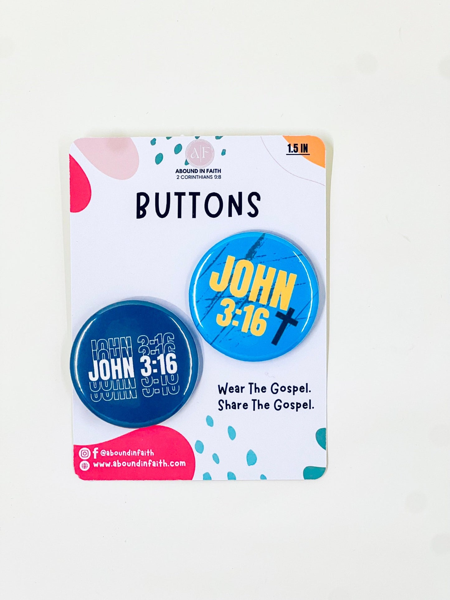 Close-up of two John 3:16 pins, one in navy blue and the other in light blue. These 1.5” pins are perfect for adding a touch of faith to any outfit, making them a great addition to everyday style or as small gifts