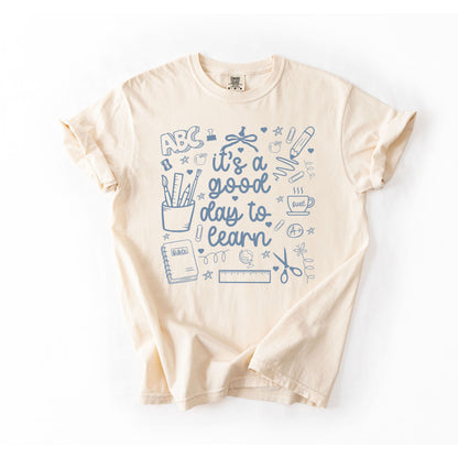 Beige t-shirt with blue educational graphics and text on a white background