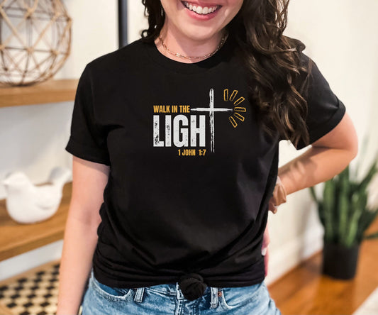 Woman wearing black Walk in the Light Christian T-Shirt with 1 John 1:7 Bible verse